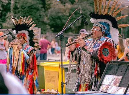 Two Native Americans playing a traditional musical instrument
