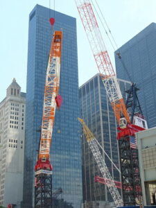 Photo of tower cranes on top of building under construction in lower Manhattan